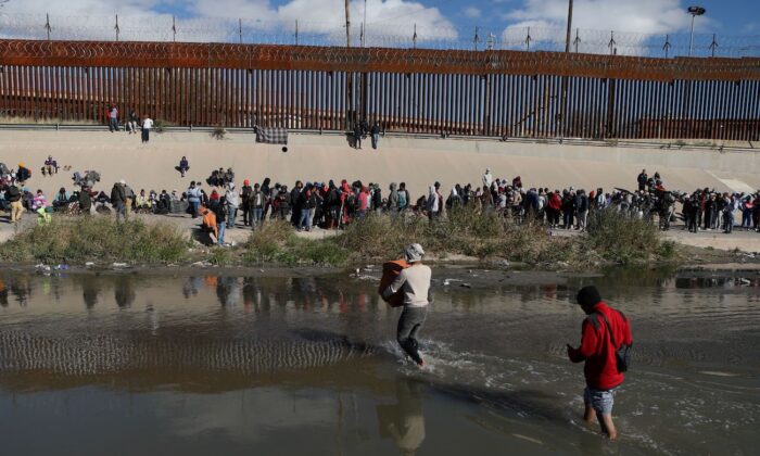 2022 年 12 月 13 日，从墨西哥奇瓦瓦州华雷斯城看到的非法移民穿过格兰德河向德克萨斯州埃尔帕索的美国边境巡逻人员投降。（Herika Martine/AFP via Getty Images）