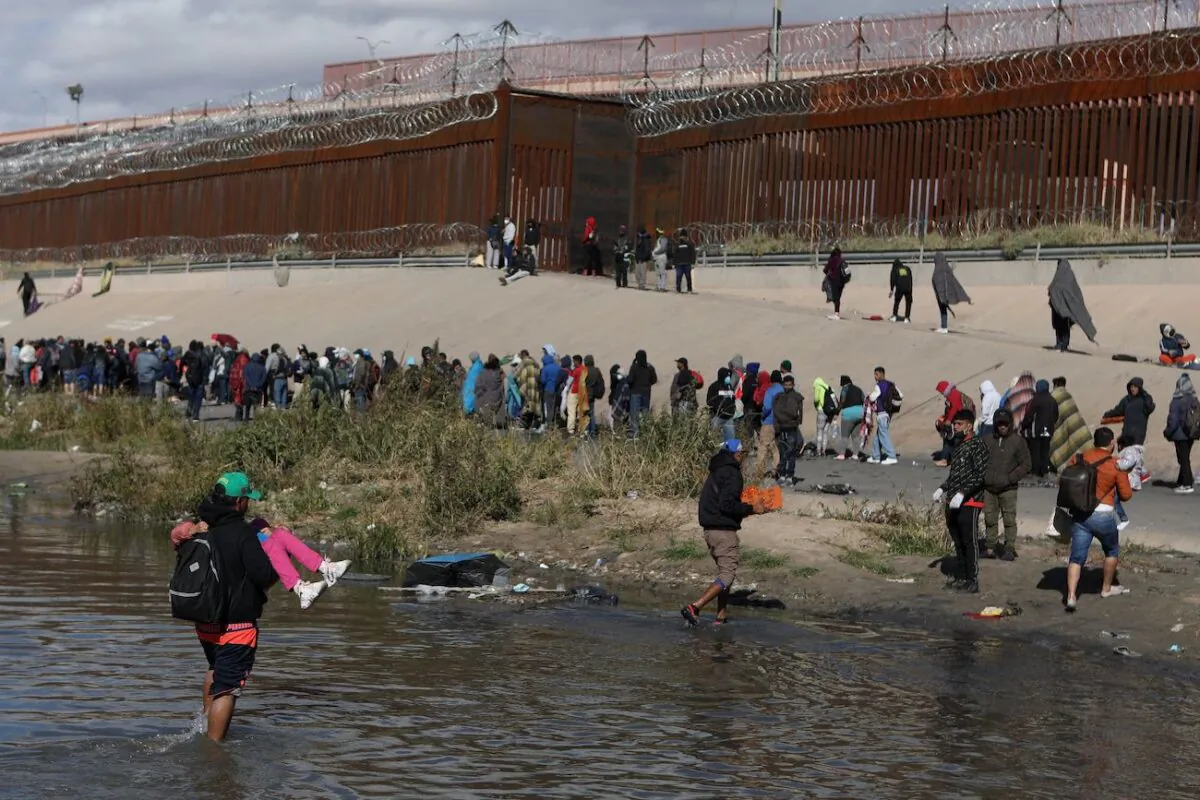 Illegal immigrants walk across the Rio Grande to surrender to U.S. Border Patrol agents in El Paso, Texas, as seen from Ciudad Juarez, Chihuahua state, Mexico, on Dec.13, 2022. (Herika Martinez/AFP via Getty Images)