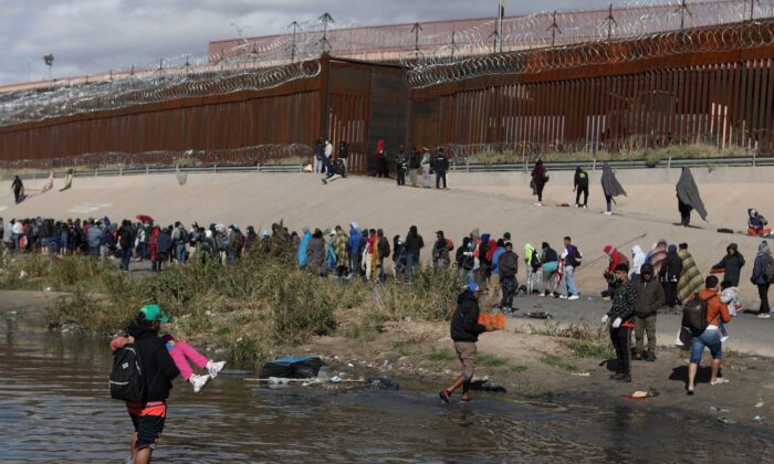 2022 年 12 月 13 日，从墨西哥奇瓦瓦州华雷斯城看到的移民穿过格兰德河向德克萨斯州埃尔帕索的美国边境巡逻人员投降。（Herika Martinez/AFP via Getty Images）