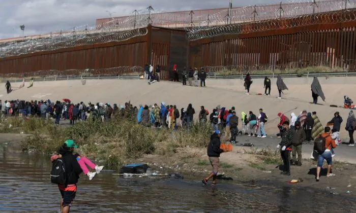 Illegal immigrants walk across the Rio Grande to surrender to U.S. Border Patrol agents in El Paso, Texas, as seen from Ciudad Juarez, Chihuahua state, Mexico, on Dec.13, 2022. (Herika Martinez/AFP via Getty Images)