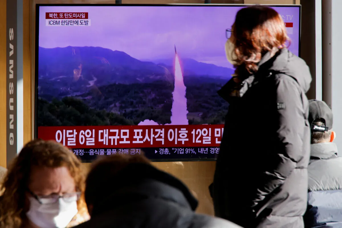 A woman walks past a TV broadcasting a news report on North Korea firing a ballistic missile off its east coast, in Seoul, South Korea, on Dec. 18, 2022. (Heo Ran/Reuters)