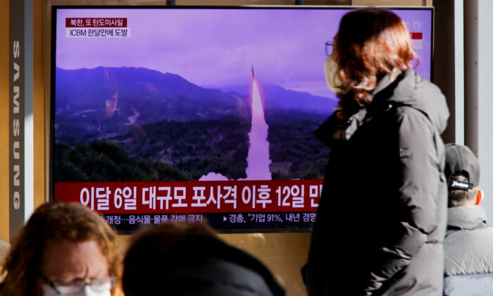 A woman walks past a TV broadcasting a news report on North Korea firing a ballistic missile off its east coast, in Seoul, South Korea, on Dec. 18, 2022. (Heo Ran/Reuters)
