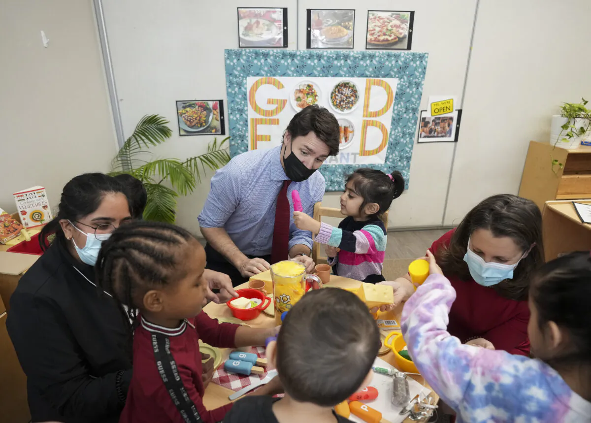 Canadian Prime Minister Justin Trudeau, back centre, plays with children in a daycare centre after reaching an agreement on $10-a-day child care with Ontario Premier Doug Ford, not pictured, in Brampton, Ont., on March 28, 2022. (Nathan Denette/The Canadian Press)