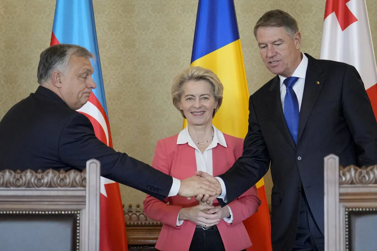 Hungarian Prime Minister Viktor Orban (L) shakes hands with Romanian President Klaus Iohannis (R) as European Commission President Ursula von der Leyen (C) smiles at the Cotroceni presidential palace in Bucharest, Romania, on Dec. 17, 2022. (Vadim Ghirda/AP Photo)