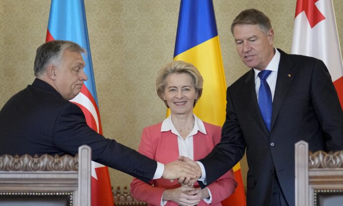 Hungarian Prime Minister Viktor Orban (L) shakes hands with Romanian President Klaus Iohannis (R) as European Commission President Ursula von der Leyen (C) smiles at the Cotroceni presidential palace in Bucharest, Romania, on Dec. 17, 2022. (Vadim Ghirda/AP Photo)