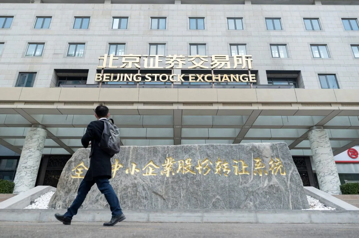 A man walks past the Beijing Stock Exchange on its first day of trading in Beijing on Nov. 15, 2021. (Wang Zhao/AFP via Getty Images)