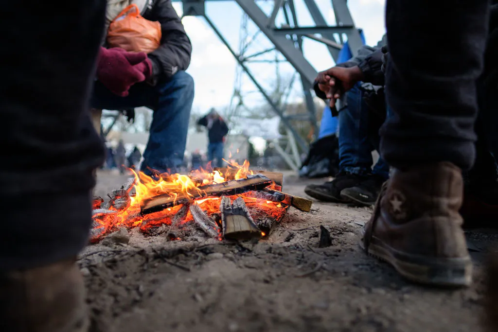File photo of a group of people warm themselves near a campfire. (Leon Neal/Getty Images)
