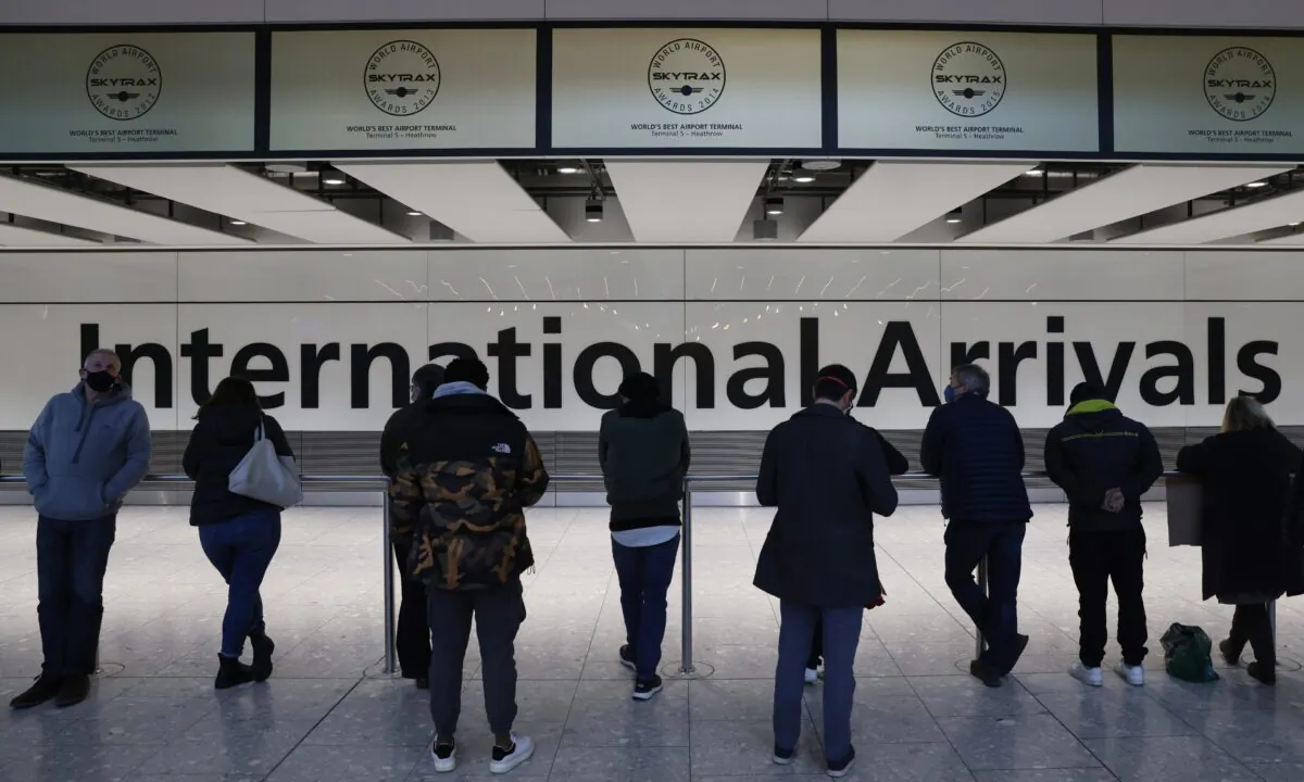 People wait at the international arrivals gate at Heathrow Terminal 5 in London, on Nov. 28, 2021. (Hollie Adams/Getty Images)