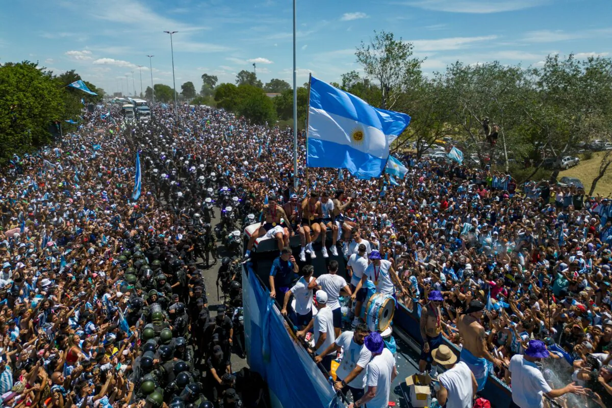 The Argentina soccer team celebrates on board a bus with a sign reading "World Champions" with supporters after winning the Qatar 2022 World Cup tournament as they tour through Buenos Aires' downtown on Dec. 20, 2022. (Tomas Cuesta/AFP via Getty Images)