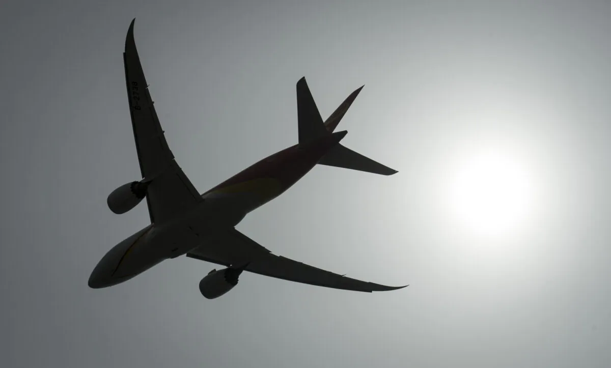 A plane is silhouetted as it takes off from Vancouver International Airport in Richmond, B.C., on May 13, 2019. (Jonathan Hayward/The Canadian Press)