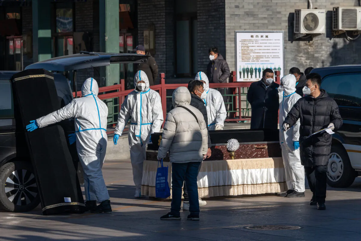 Workers in protective gear handle a coffin at the Dongjiao Funeral Parlor, reportedly designated to handle COVID-19 fatalities, in Beijing on Dec. 19, 2022. (Bloomberg via Getty Images)