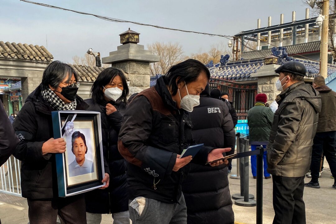 Relatives carry a picture frame of a loved at a crematorium in Beijing on Dec. 20, 2022. (Noel Celis/AFP via Getty Images)