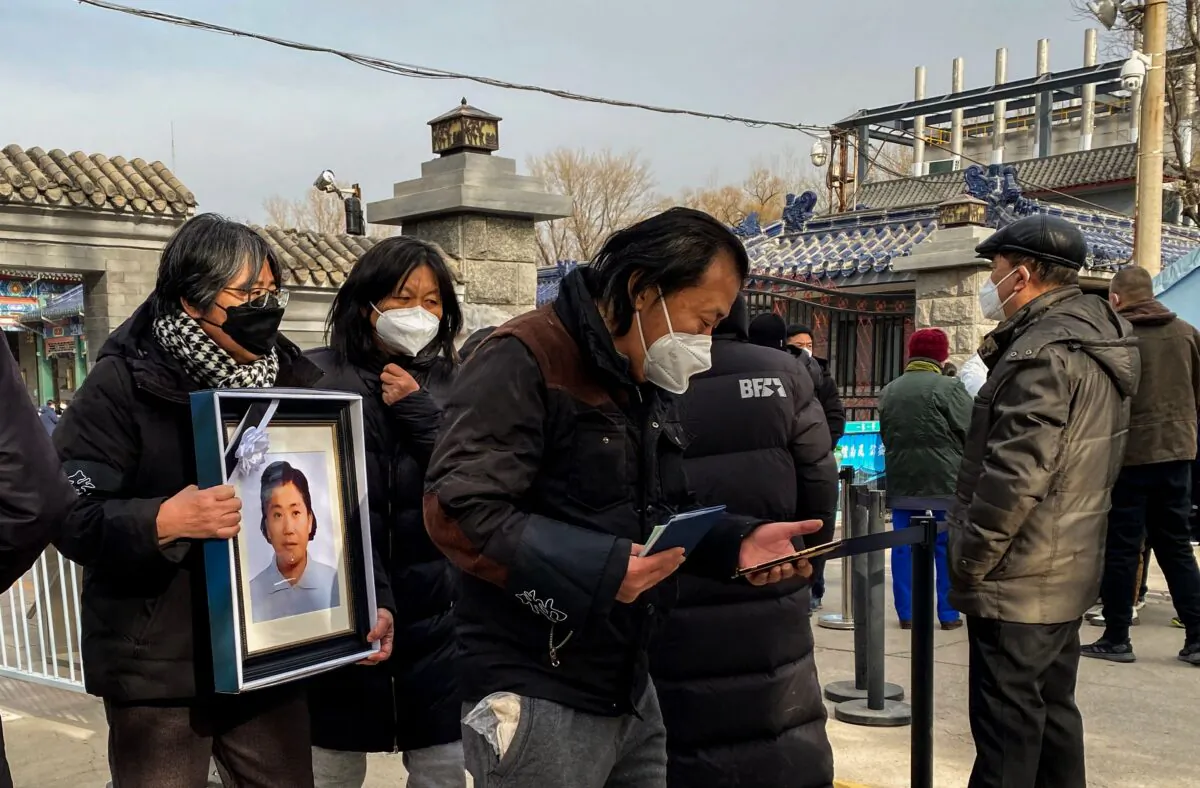 Relatives carry a picture frame of a loved at a crematorium in Beijing on Dec. 20, 2022. (Noel Celis/AFP via Getty Images)