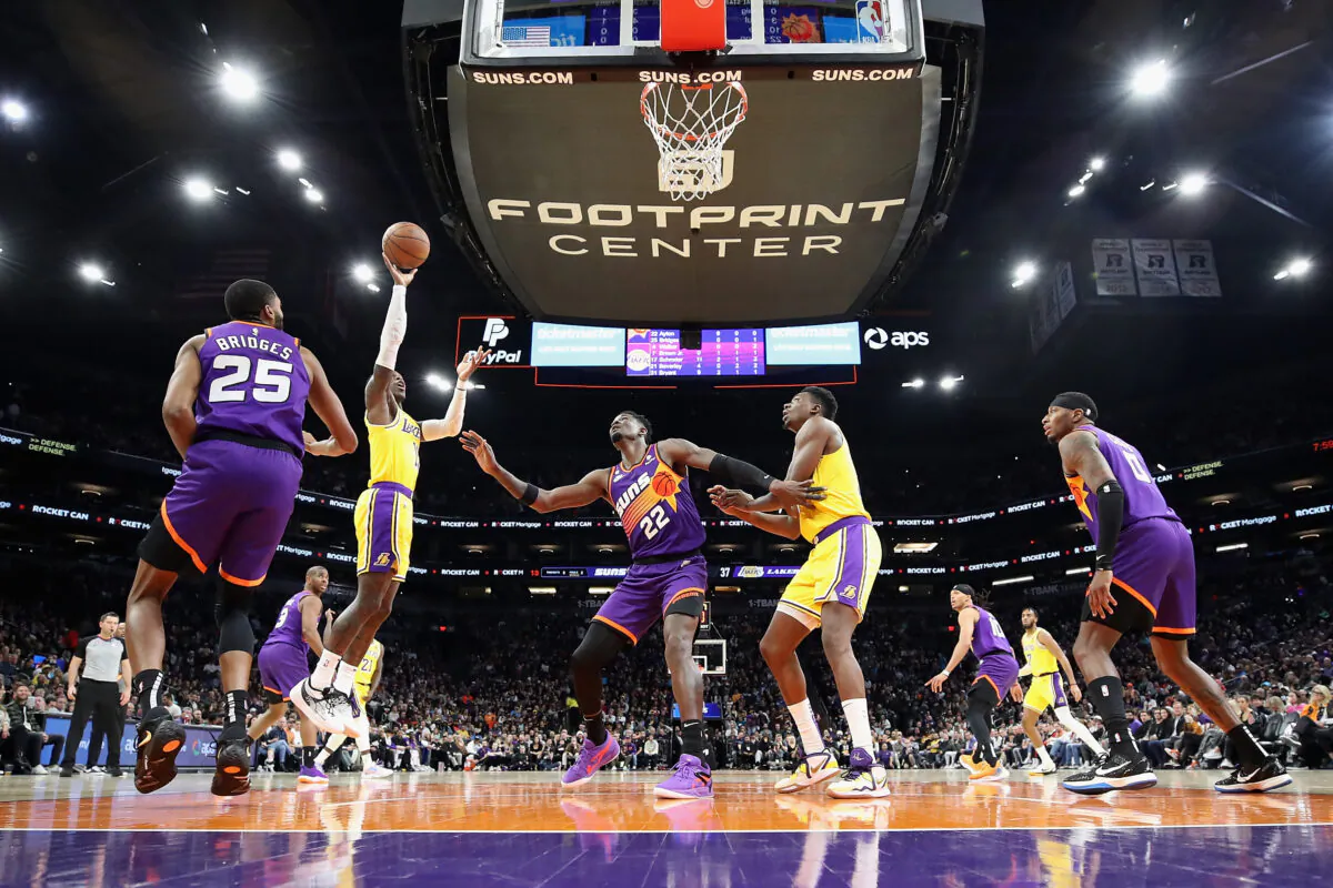 Dennis Schroder (17) of the Los Angeles Lakers attempts a shot over Deandre Ayton (22) of the Phoenix Suns during the first half of the NBA game at Footprint Center in Phoenix on Dec. 19, 2022. (Christian Petersen/Getty Images)