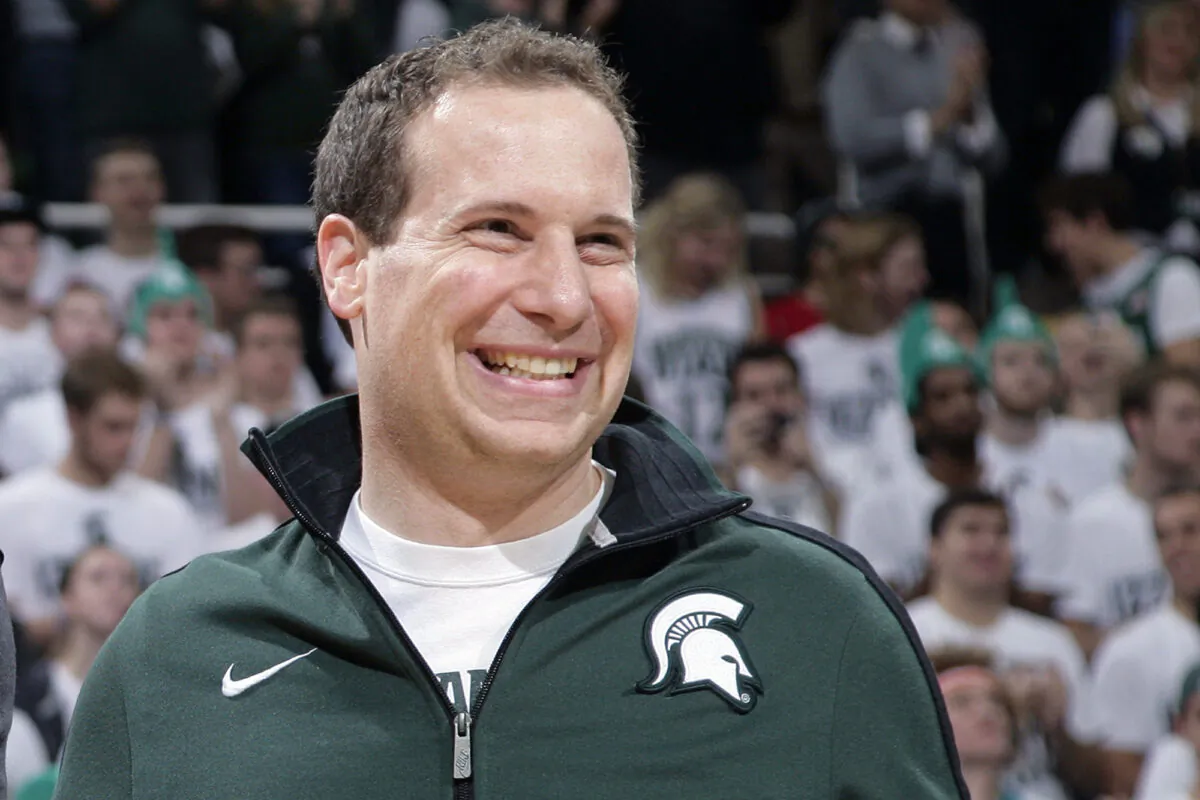 Former Michigan State player Mat Ishbia laughs as he are introduced along with Michigan State's 2000 national championship NCAA college basketball team during halftime of the Michigan State-Florida game in East Lansing, Mich.  Mortgage executive Mat Ishbia has agreed in principle to buy the Phoenix Suns and Phoenix Mercury from the embattled owner Robert Sarver for $4 billion, a person with knowledge of the negotiations told The Associated Press on Dec. 20, 2022. (Al Goldis/AP Photo)
