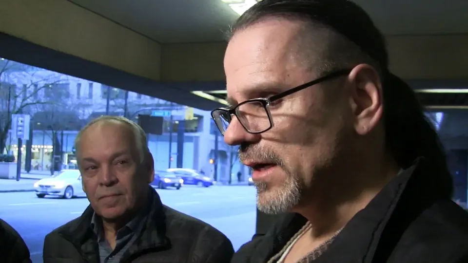 Wade Skiffington is seen speaking to reporters beside his father, Tom, left, in a still frame taken from video footage outside of court in Vancouver on Jan. 23, 2019. (The Canadian Press/Camille Bains)