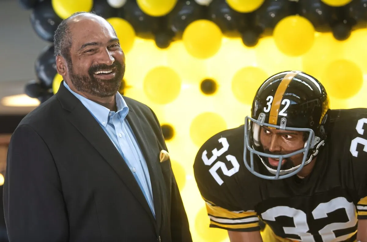 Former Pittsburgh Steelers running back Franco Harris stands next a statute of himself at Pittsburgh International Airport near Pittsburgh on Sept. 12, 2019. (Nate Guidry/Pittsburgh Post-Gazette via AP)