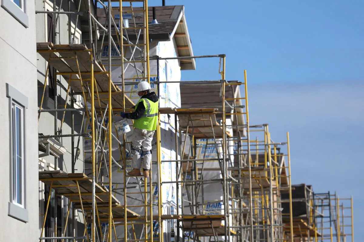 A worker makes repairs to a home under construction at the Lennar Bridgeway home development in Newark, Calif., on Dec. 15, 2021. (Justin Sullivan/Getty Images)