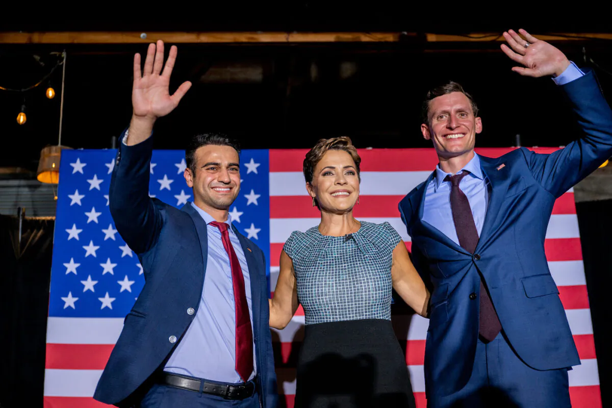 Republican candidate for state attorney general Abraham Hamadeh, Republican gubernatorial candidate Kari Lake, and Republican U.S. senatorial candidate Blake Masters wave to supporters at the conclusion of a campaign event on the eve of the primary at the Duce bar in Phoenix, Ariz., on Aug. 1, 2022. (Brandon Bell/Getty Images)