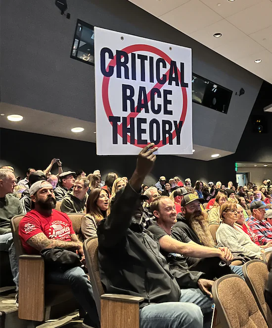 A man holds up a sign at a school board meeting in Temecula, Calif., on Dec. 13, 2022. (The Epoch Times)
