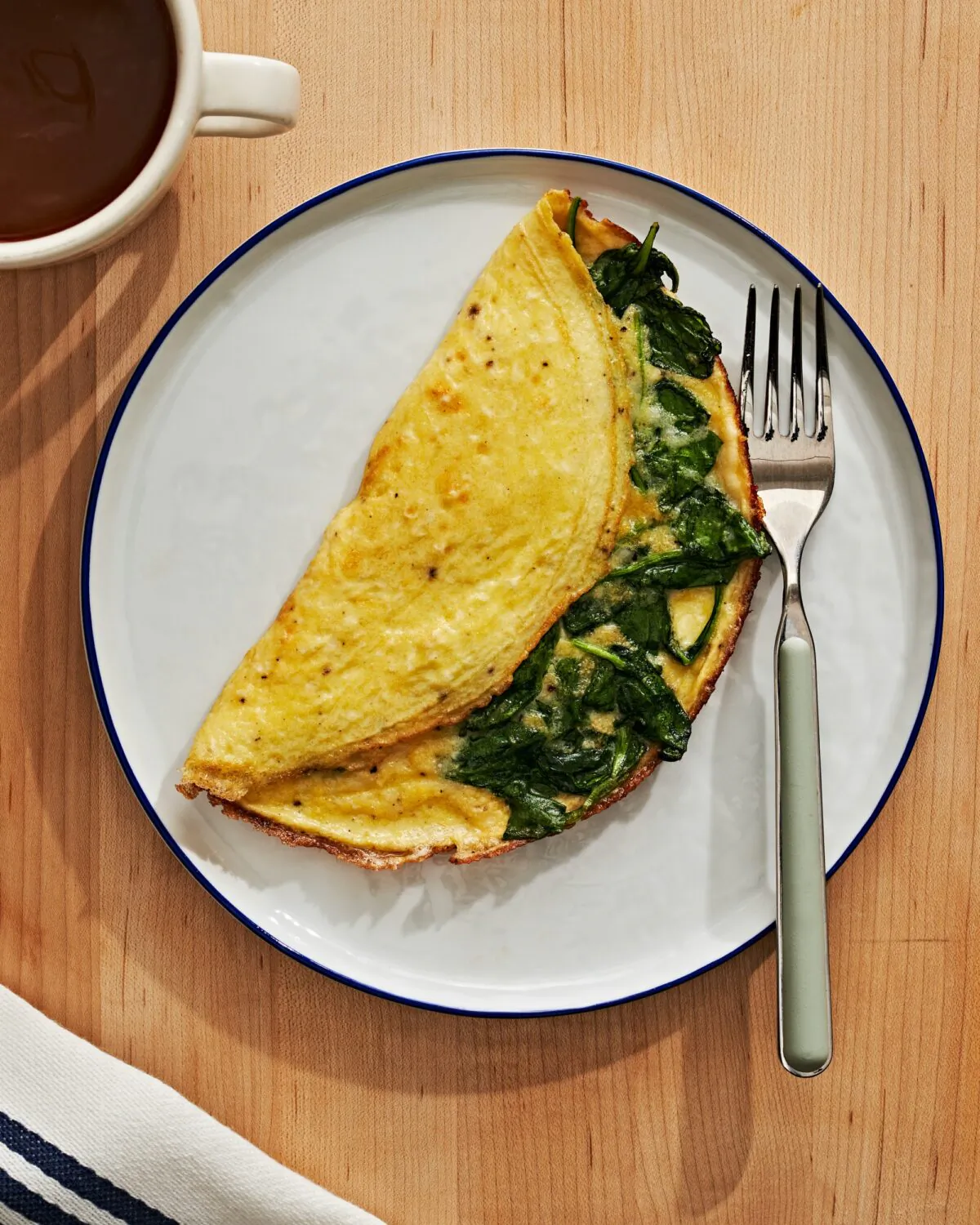 This soft, fluffy omelet is stuffed with baby spinach leaves and Parmesan cheese. (Andrew Bull/TNS)