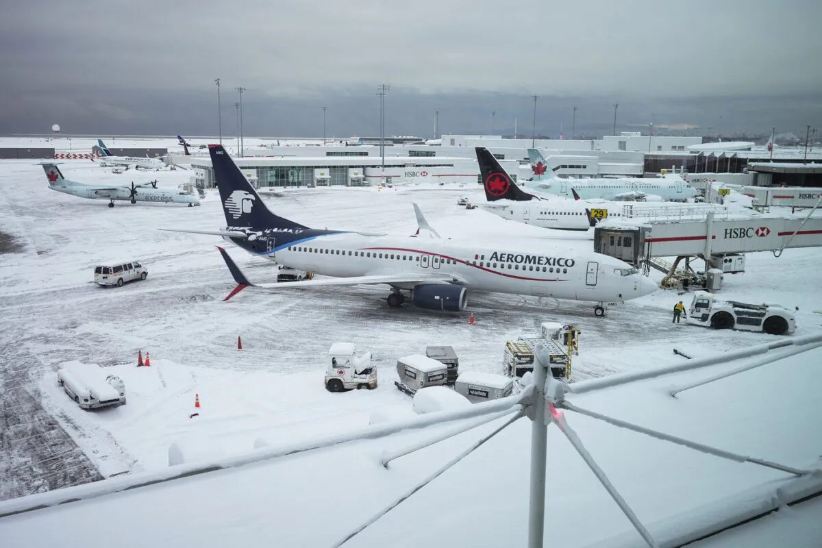 Aircraft are seen parked at gates at Vancouver International Airport after a snowstorm impaired operations leading to cancellations and major delays, in Richmond, B.C., on Dec. 20, 2022. (The Canadian Press/Darryl Dyck)
