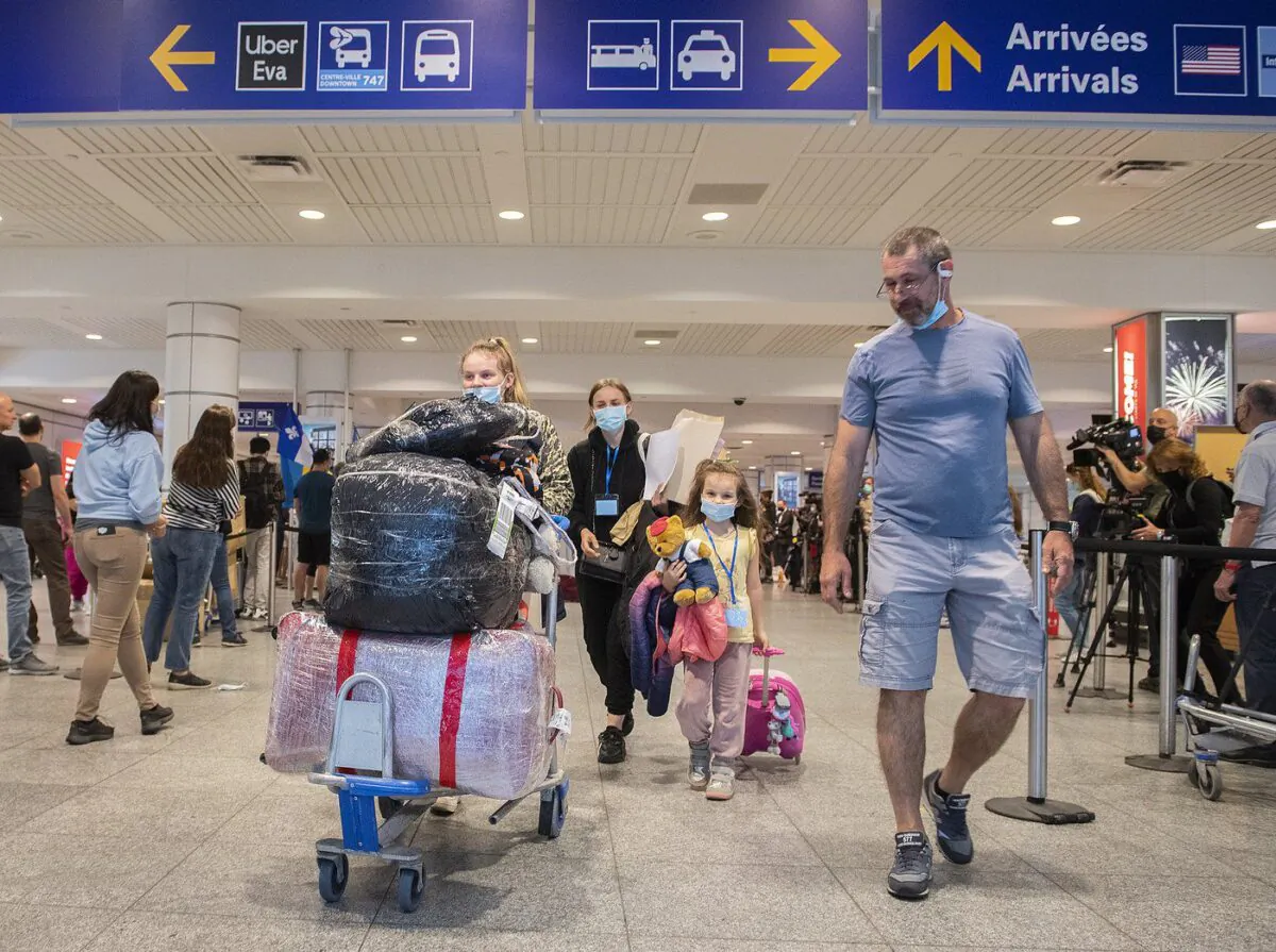 Ukrainian nationals fleeing the ongoing war in Ukraine, left, arrive in Montreal, May 29, 2022. (The Canadian Press/Graham Hughes)