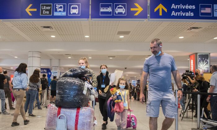 Ukrainian nationals fleeing the ongoing war in Ukraine, left, arrive in Montreal, May 29, 2022. (The Canadian Press/Graham Hughes)
