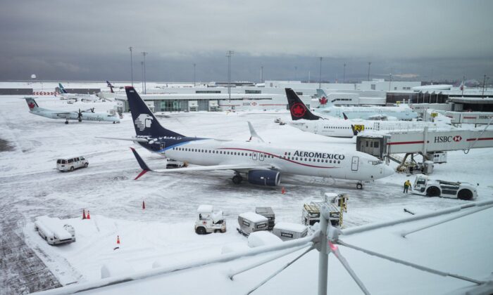 Aircraft are seen parked at gates at Vancouver International Airport after a snowstorm impaired operations leading to cancellations and major delays, in Richmond, B.C., on Dec. 20, 2022. (The Canadian Press/Darryl Dyck)
