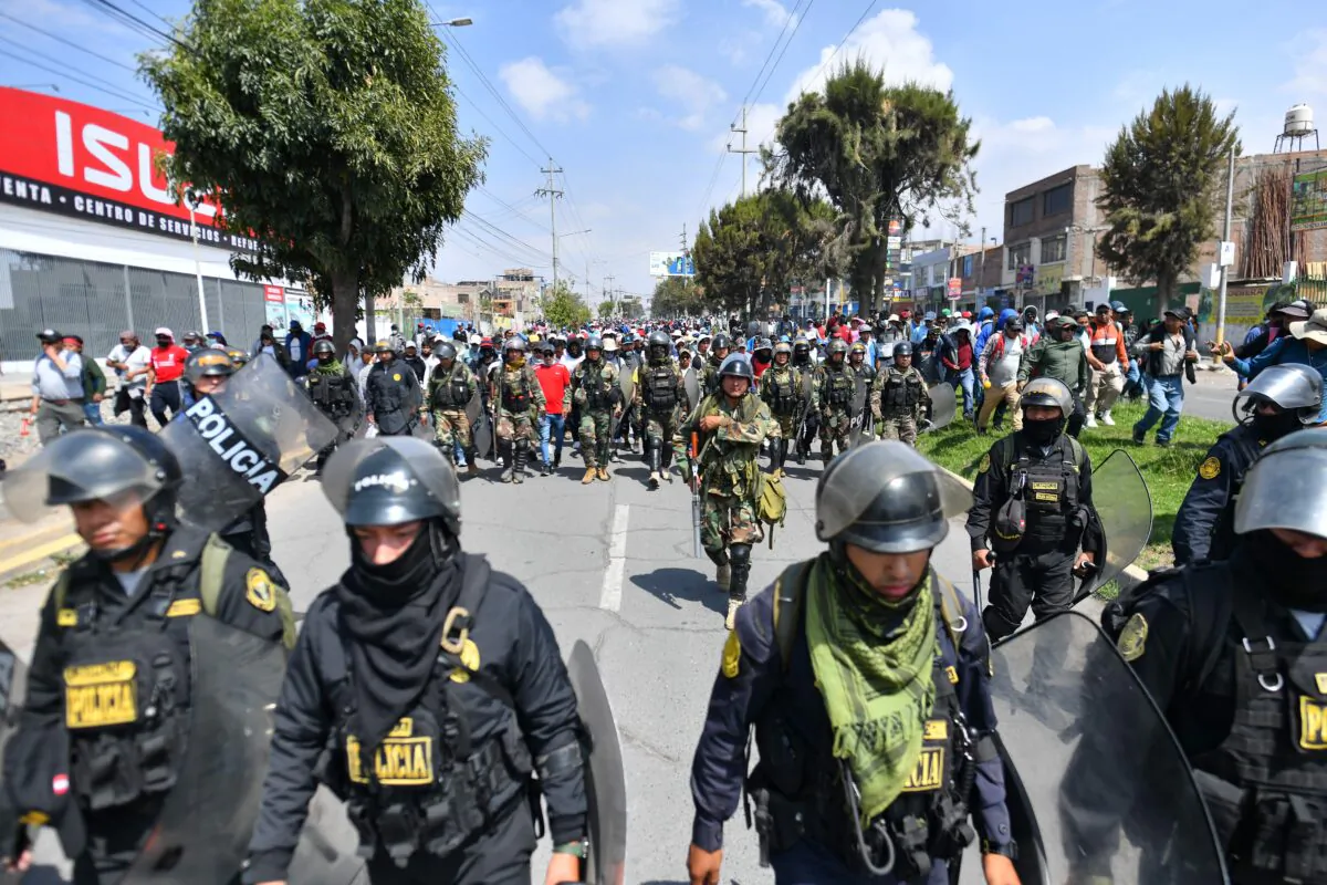 Members of the police escort supporters of former President Pedro Castillo while they march to the center of the city of Arequipa, Peru, demanding the closure of Congress and the release of Castillo, on Dec. 14, 2022. (Diego Ramos/AFP via Getty Images)