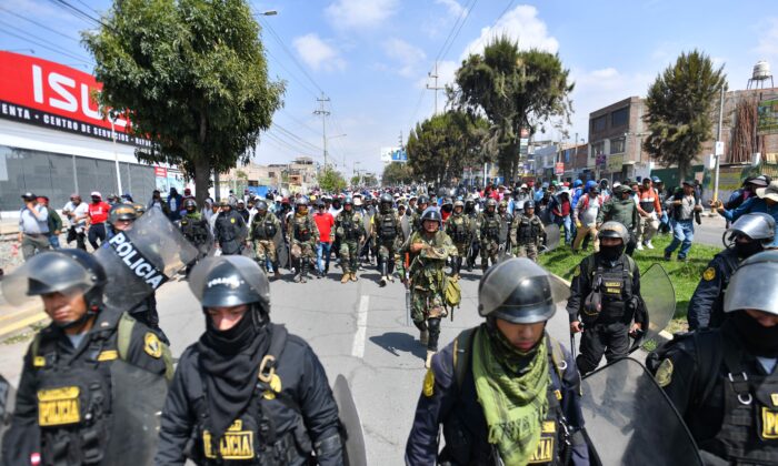 Members of the police escort supporters of former President Pedro Castillo while they march to the center of the city of Arequipa, Peru, demanding the closure of Congress and the release of Castillo, on Dec. 14, 2022. (Diego Ramos/AFP via Getty Images)