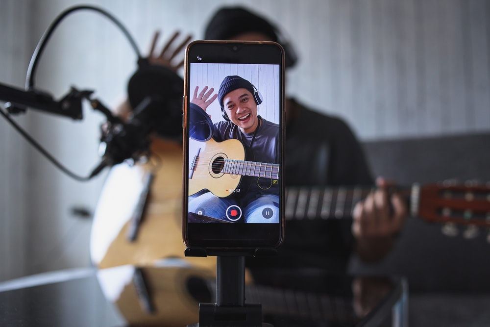 Asian,Influencer,Playing,Guitar,During,Podcast,Or,Live,Video,Broadcast