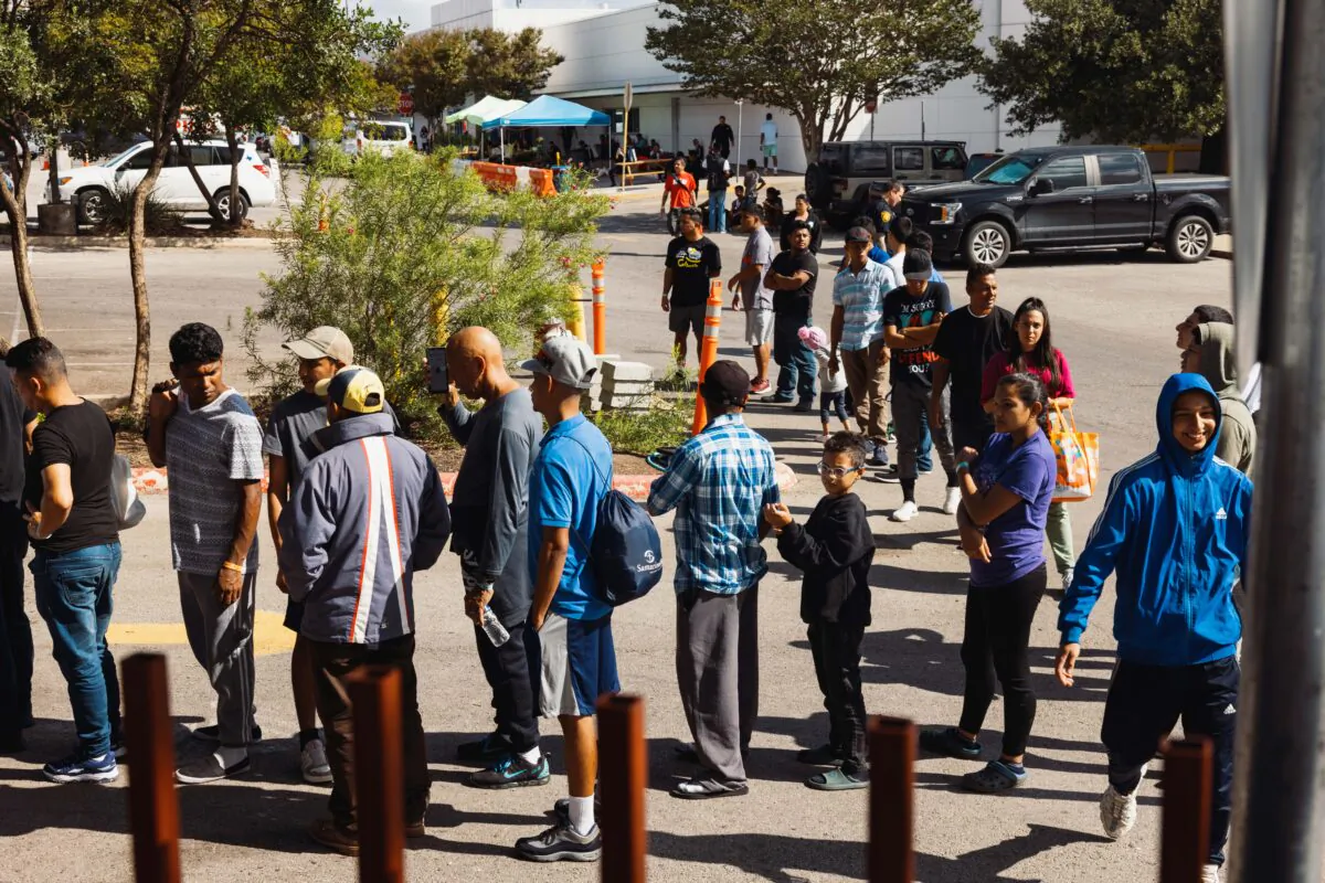 Illegal immigrants wait outside a Migrant Resource Center to receive food from San Antonio Catholic Charities in San Antonio, Texas, on Sept. 19, 2022. (Jordan Vonderhaar/Getty Images)