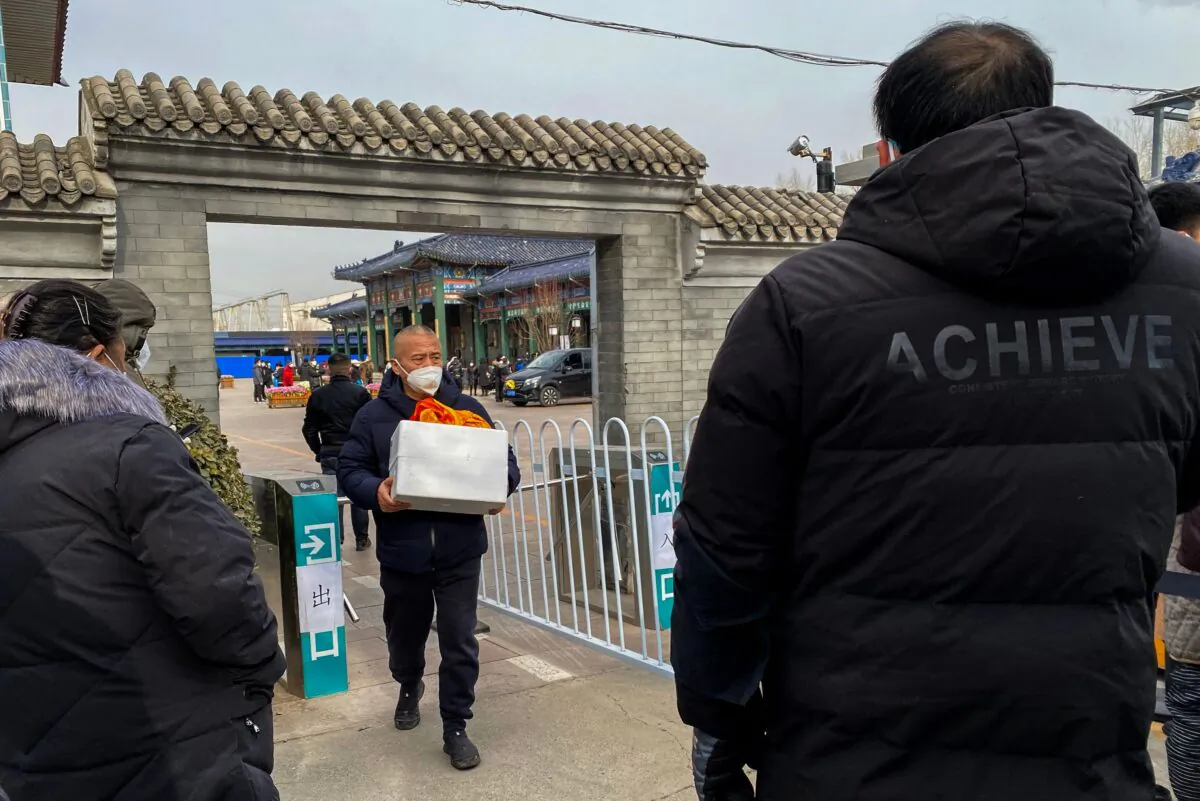 A man carries an urn of a loved one's ashes at a crematorium in Beijing on Dec. 20, 2022. (Noel Celis/AFP via Getty Images)