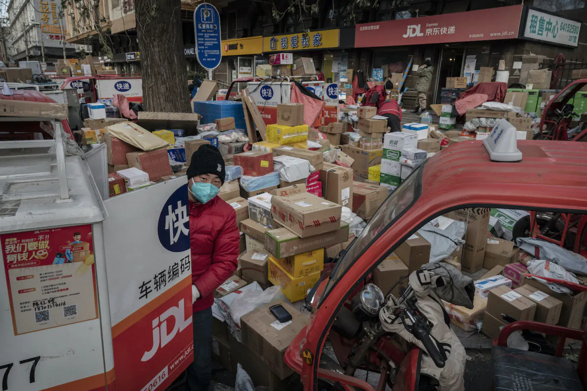 A delivery driver organizes packages in the street that are part of a backlog due to COVID-19 outbreaks outside a depot in Beijing on Dec. 21, 2022. The rapid spread of the virus across China has left many delivery services short-staffed as drivers become infected, impacting the supply chain. (Kevin Frayer/Getty Images)