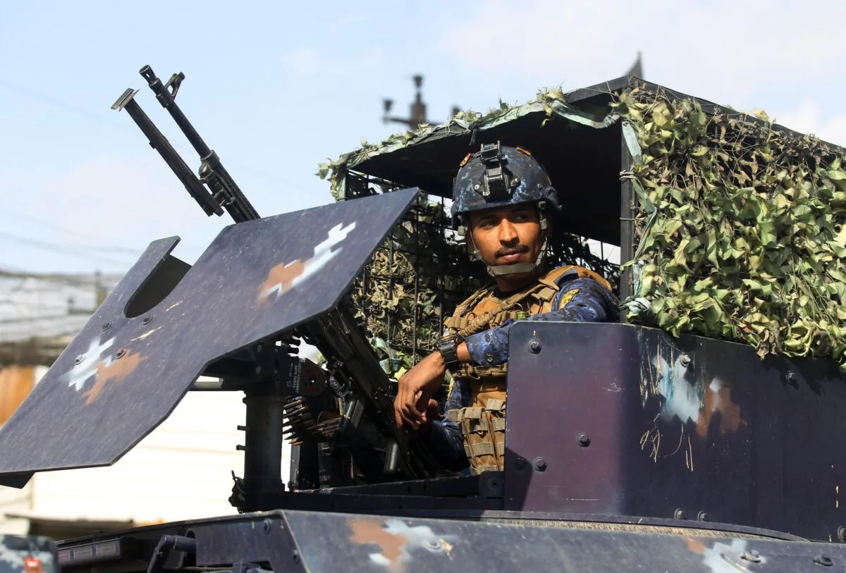 A member of the Iraqi federal police forces sits inside an armoured vehicle at a checkpoint in a street in the capital Baghdad on Jan. 29, 2021. (Ahmad Al-Rubaye/AFP via Getty Images)