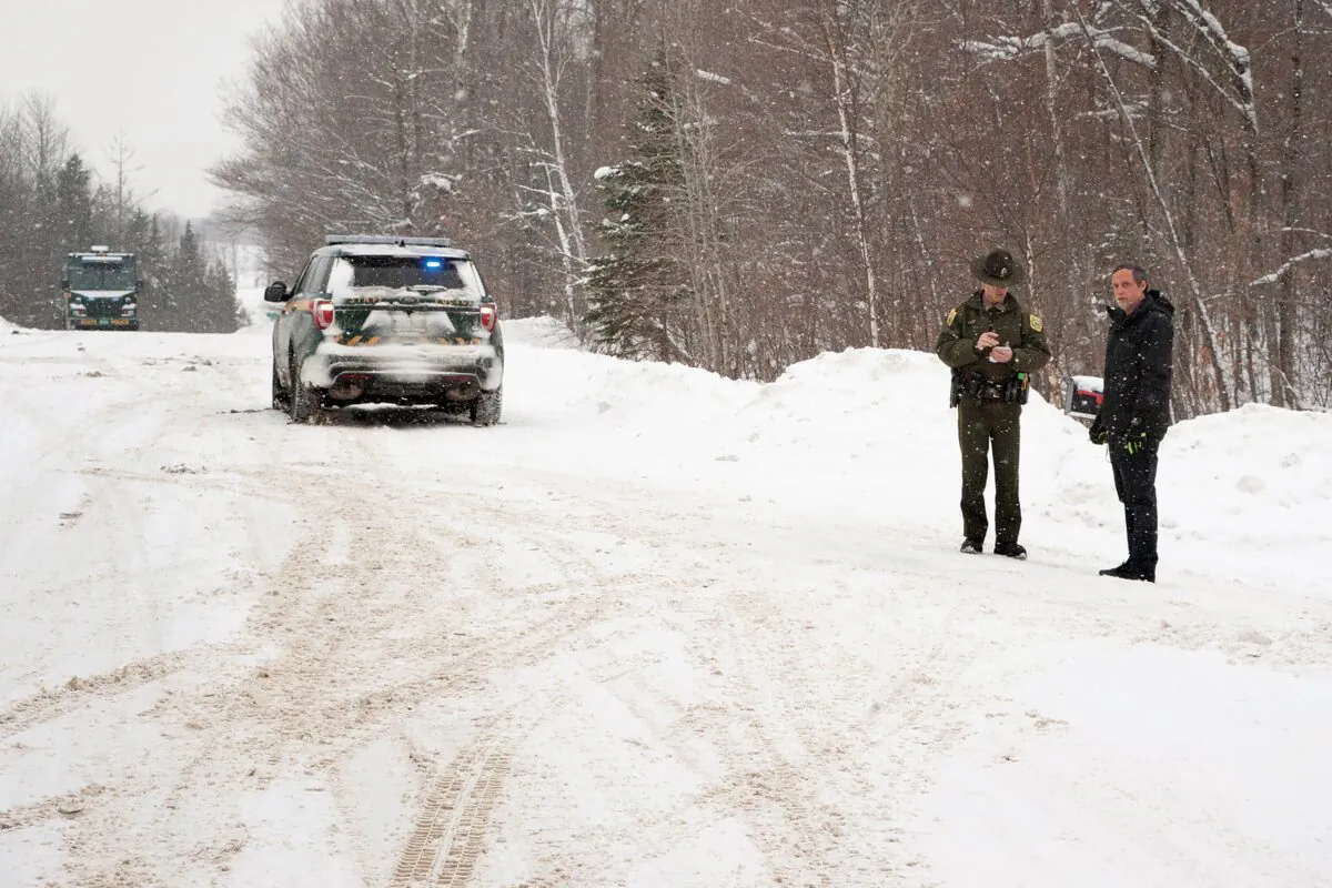 A Vermont State Trooper (C) speaks to a homeowner near an area on Peacham Road, in Barnet, Vt., where the body of Gregory Davis was found, on Jan. 8, 2018. (Dana Gray/Caledonian-Record via AP)