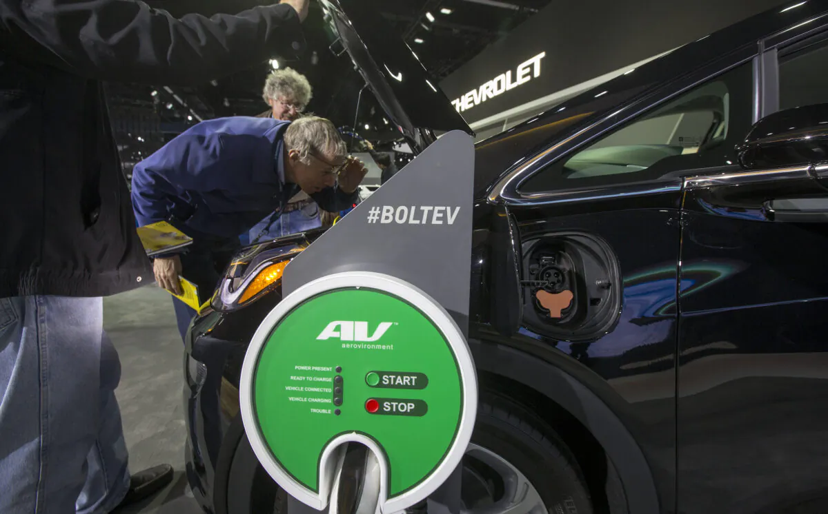 People look under the hood of a Chevrolet Bolt EV at the auto trade show, AutoMobility LA, at the Los Angeles Convention Center in Los Angeles, Calif., on Nov. 29, 2018. (David McNew/Getty Images)