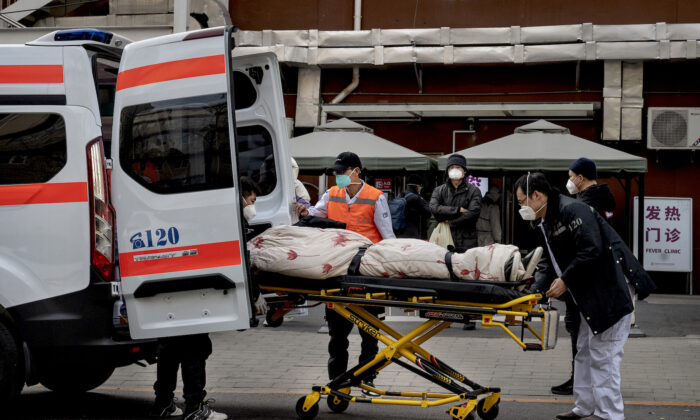 Ambulance drivers unload a patient outside a clinic treating COVID-19 patients in Beijing on Dec. 21, 2022. (Kevin Frayer/Getty Images)