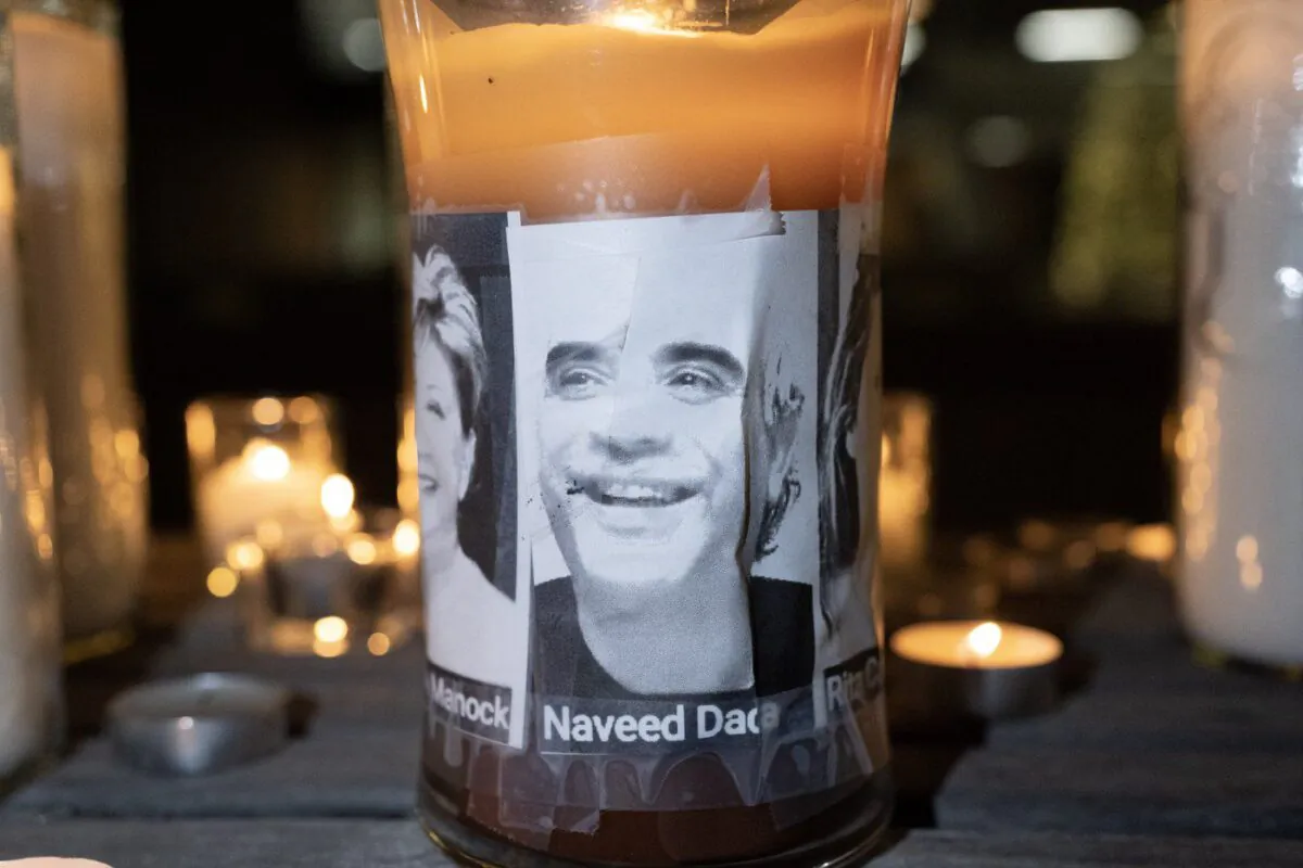 A photo of Naveed Dada, who died in a deadly condo shooting, is displayed on a candle at a vigil for the victims in Vaughan, Ont., on Dec, 21, 2022. (The Canadian Press/Arlyn McAdorey)