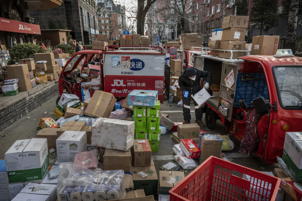 A delivery driver organizes packages outside a depot in Beijing, China, on Dec. 21, 2022. The current outbreak of COVID-19 in China has caused disruptions in the supply chain as workers fall ill. (Kevin Frayer/Getty Images)