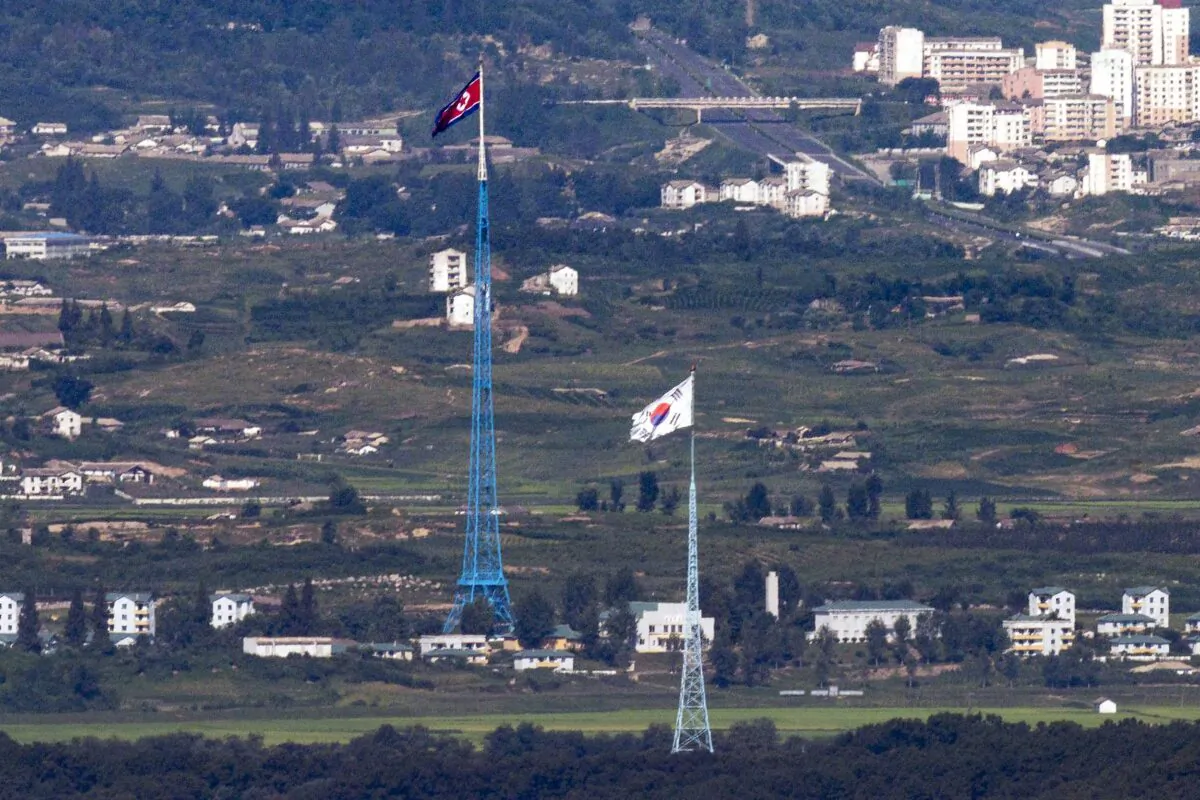 Flags of North Korea, rear, and South Korea, front, flutter in the wind from the border area between two Koreas in Paju, South Korea, on Aug. 9, 2021. (Im Byung-shik/Yonhap via AP)