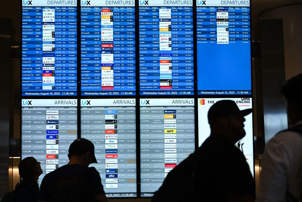 Passengers look at flight departure information boards in the West Gates expansion area at Los Angeles International Airport (LAX) in Los Angeles on Aug. 10, 2022. (Patrick Fallon/AFP via Getty Images)