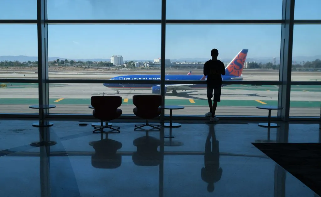A person watches planes take off from the Tom Bradley International terminal at Los Angeles International Airport (LAX) in Los Angeles, on Aug. 10, 2022. (Chris Delmas/AFP via Getty Images)
