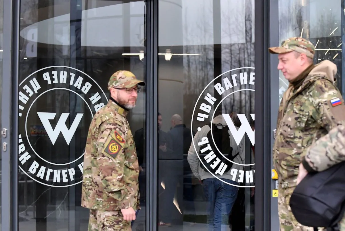 Visitors wearing military camouflage stand at the entrance of the "PMC Wagner Centre," associated with the founder of the Wagner private military group (PMC) Yevgeny Prigozhin, during the official opening of the office block on the National Unity Day, in St. Petersburg, on Nov. 4, 2022. (Olga Maltseva/AFP via Getty Images)