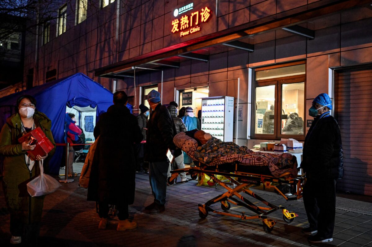 Zdravotničtí pracovníci převážejí pacienta na nemocniční kliniku uprostřed pandemie covidu-19 v Pekingu, 21. prosince 2022. (Jade Gao/AFP via Getty Images)
