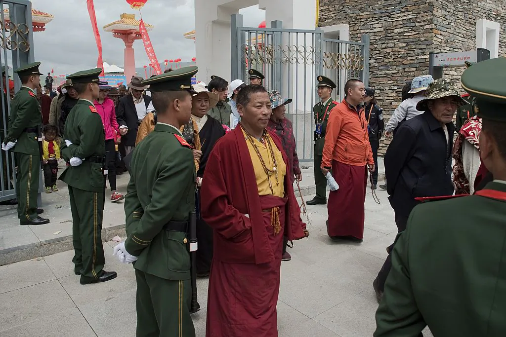 Chinese paramilitary police (in green uniforms) secure an exit as Tibetans monks (C) walk out from a stadium at the end of a local government sponsored festival in Yushu, in the China's northwestern Qinghai Province, on July 25, 2016.
(Nicolas Asfouri/AFP via Getty Images)