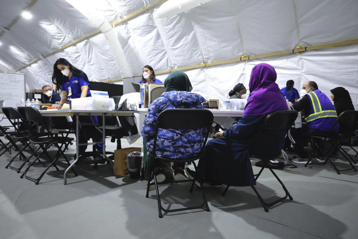 Afghan refugee women register to be seen by a doctor inside the medical tent at Liberty Village on Joint Base McGuire-Dix- Lakehurst, N.J., on Dec, 2, 2021. (Barbara Davidson/Pool via AP)