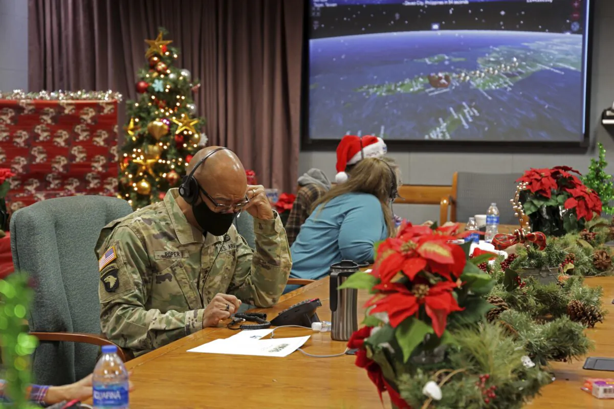 Volunteers answer phones and emails from children around the globe during annual NORAD Tracks Santa event at Peterson Air Force Base in Colorado Springs, Colo., on Dec. 24, 2021. (Jhomil Bansil/U.S. Department of Defense via AP)