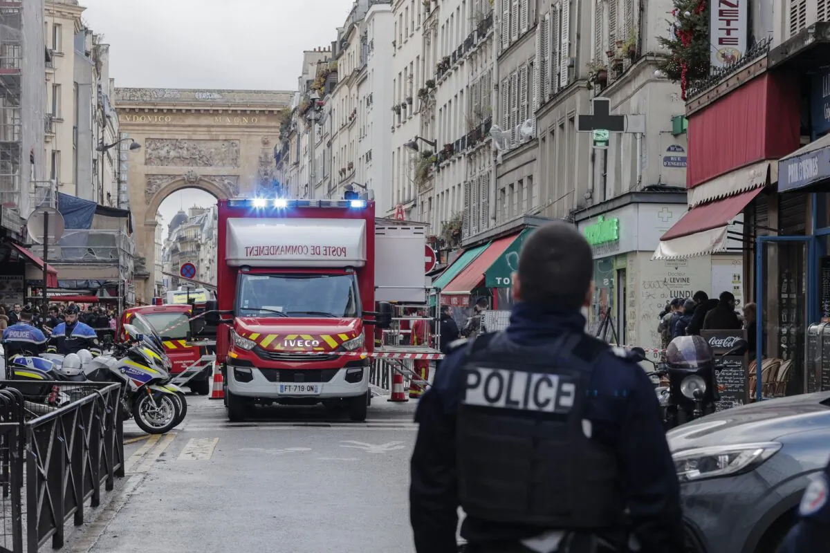 A police officer stands next to the cordoned off area where a shooting took place in Paris on Dec. 23, 2022. (Lewis Joly/AP Photo)